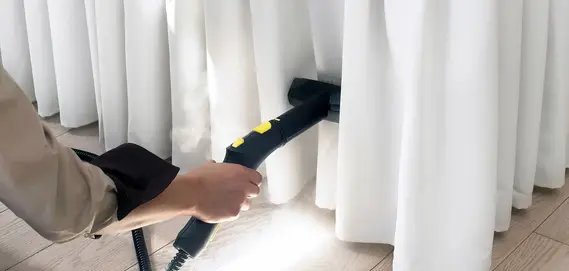 A person uses a steam cleaner